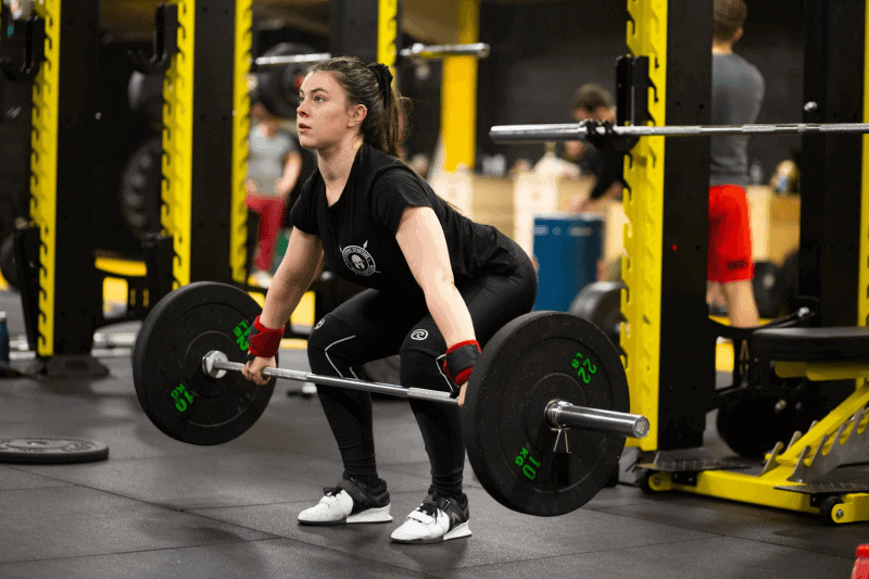 A woman working out using a barbell