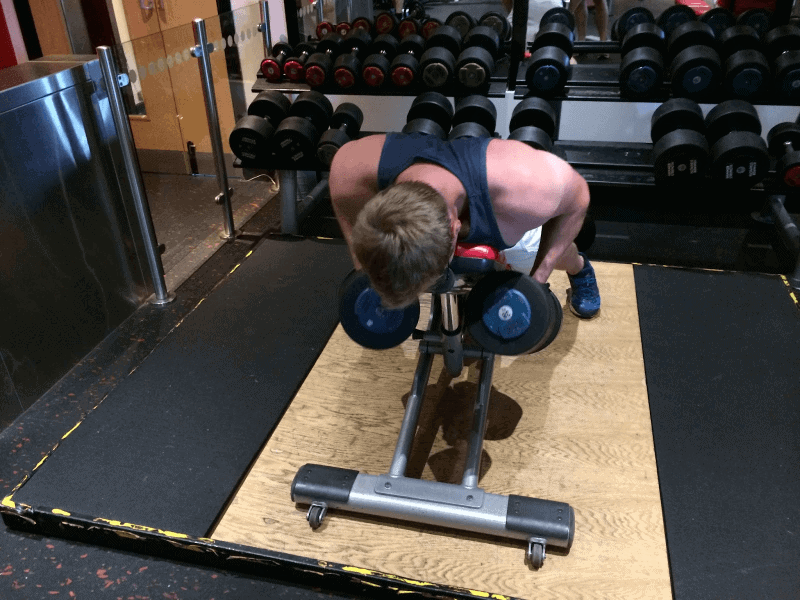 Steve working out using a weight bench and a set of adjustable dumbbells